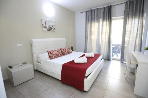 a bedroom with a white bed with a red blanket at B&B Le Grazie Tropea in Tropea