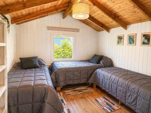 a room with two beds and a window at Cabañas Chucao 2 in San Martín de los Andes