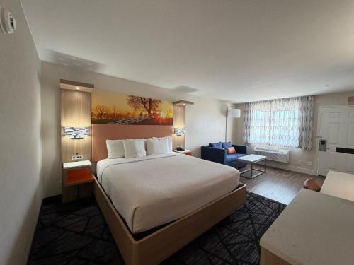 a hotel room with a bed and a living room at Days Inn by Wyndham Granbury in Granbury