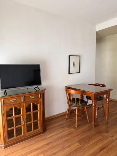 a living room with a table and a tv and a table and chair at Depto calle 51 in La Plata