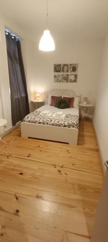 a bedroom with a bed and a wooden floor at Boho House Terrace in Porto