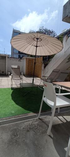 a table and chair with an umbrella on a patio at Boho House Terrace in Porto
