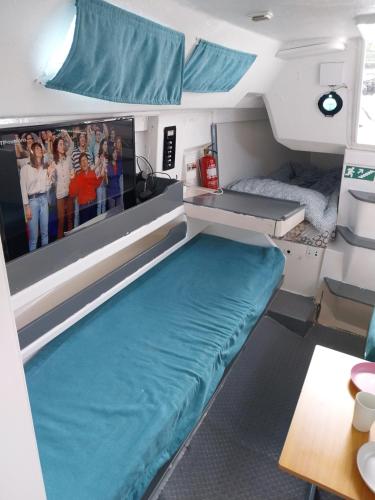 a bed in the middle of a room with a tv at Navegar no Douro - Navegação e Turismo Unipessoal, Lda in Vila Nova de Gaia
