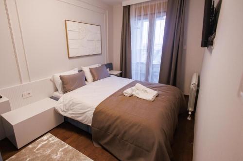 a bedroom with a bed with two towels on it at Tilia Lux apartmani in Čačak
