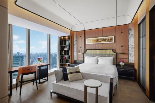 a bedroom with a bed and a desk and a couch at Conrad Shanghai in Shanghai