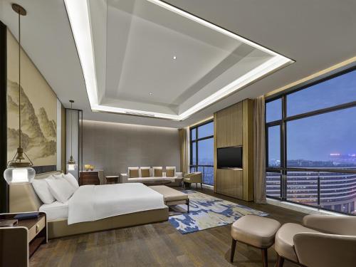 a hotel room with a bed and a large window at Doubletree By Hilton Quzhou in Quzhou