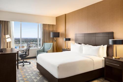 a hotel room with a large bed and a desk at Doubletree By Hilton Pointe Claire Montreal Airport West in Pointe-Claire