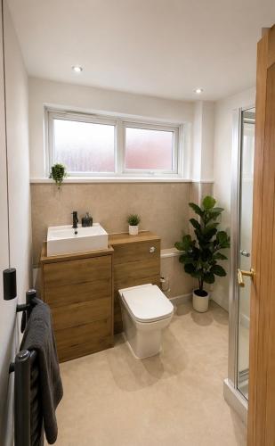 a bathroom with a toilet and a sink and a window at Golden Sands Escape Weymouth Entire House in Wyke Regis