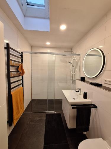 a white bathroom with a sink and a mirror at Hill Star in Mönchengladbach