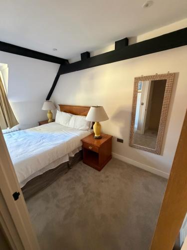 a bedroom with a bed and a mirror at Windsor Flat 90C in Windsor