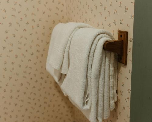 a towel rack with white towels hanging on a wall at Strassner Suites - Imy Suite in Hermann