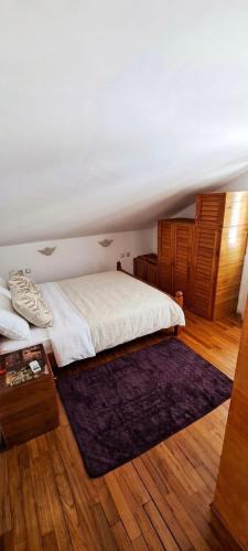 a bedroom with a white bed and a purple rug at Apartmani Fico II in Sveti Stefan