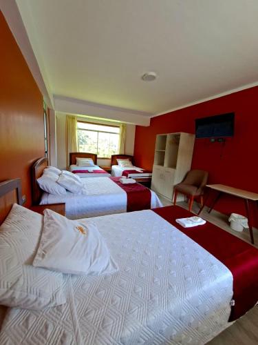 a hotel room with four beds with red walls at Hotel Paraíso in San Antonio