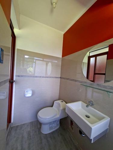 a bathroom with a toilet and a sink at Hotel Paraíso in San Antonio