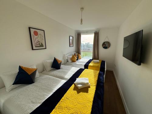 two twin beds in a room with a window at Stunning 2Bedrooms, 2Baths, Balcony, Parking in Colindale