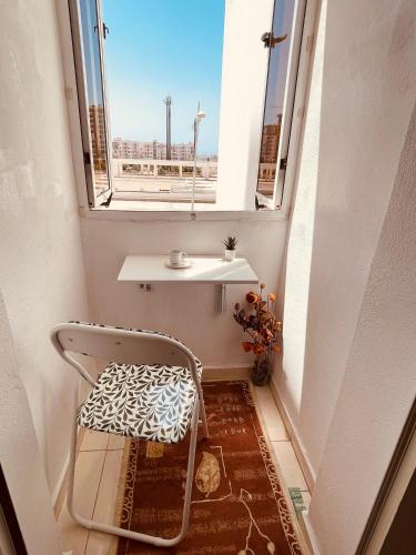 a chair sitting in a hallway with a window at Swiss Home in Agadir
