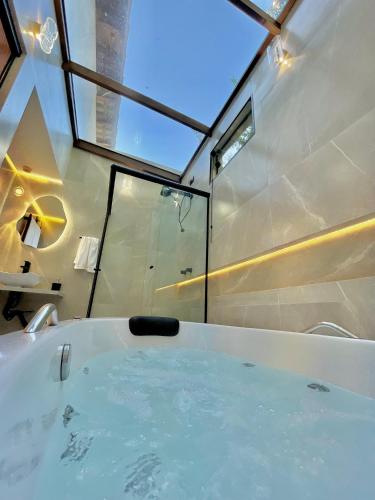 a bathroom with a bath tub with a window at Estalagem Cachoeira do Pimenta in Cunha