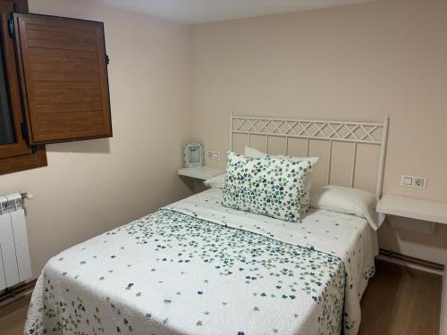 a bedroom with a bed with a blue and white bedspread at Casa Os Lindeiros in Arzúa