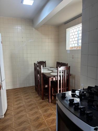 a kitchen with a table and chairs and a stove at Aluga-se Casa Espaçosa - 2 Quartos in São Luís