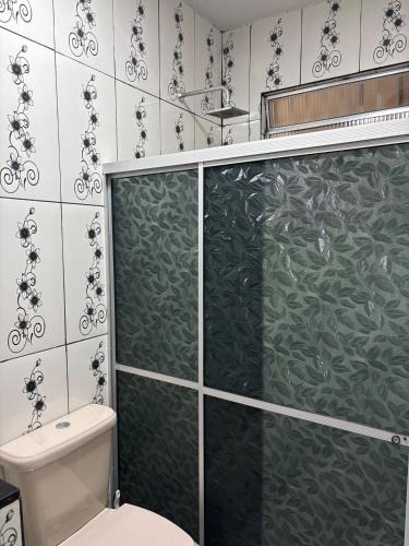 a bathroom with a toilet and a glass shower door at Aluga-se Casa Espaçosa - 2 Quartos in São Luís