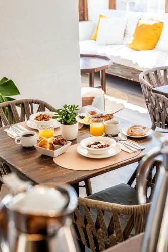 a wooden table with plates of food on it at Outsite Ibiza - Work, Connect, Explore in Es Cana