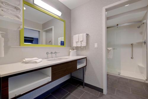 a bathroom with a sink and a mirror and a shower at Hampton Inn & Suites Marina in Marina