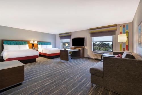 a hotel room with two beds and a couch at Hampton Inn & Suites Marina in Marina