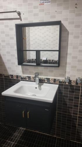 a bathroom with a white sink and a mirror at راحتي هنا in Riyadh