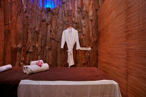 a room with a bed with a robe on a wooden wall at Ekho Safari Tissa in Tissamaharama