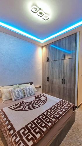 a bedroom with a large bed with a blue light at LH Appart 1 bel appartement cosy, vu sur montagnes, proche du lac de Bin el Ouidane et de cascades d'Ouzoud in Afourer