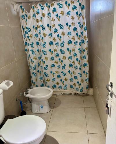 a bathroom with a toilet and a shower curtain at Duplex DEL CARMEN in Santiago del Estero