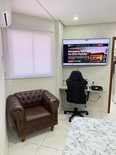 a bedroom with a couch and a desk and a television at Centro de Vitoria in Vitória