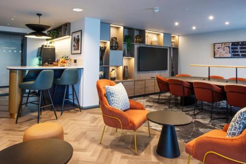 a waiting room with orange chairs and a bar at Crowne Plaza Birmingham City by IHG in Birmingham