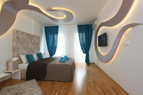 a bedroom with a bed with blue pillows at Riviera 2 New Belgrade studio apartment, parking 5 evra dan in Belgrade