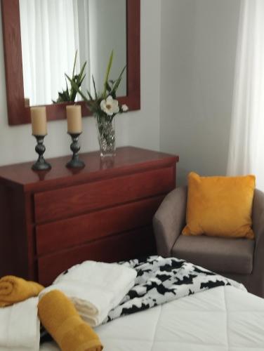 a bedroom with a bed and a dresser and a chair at Casa do Lavrador in Ponta Delgada