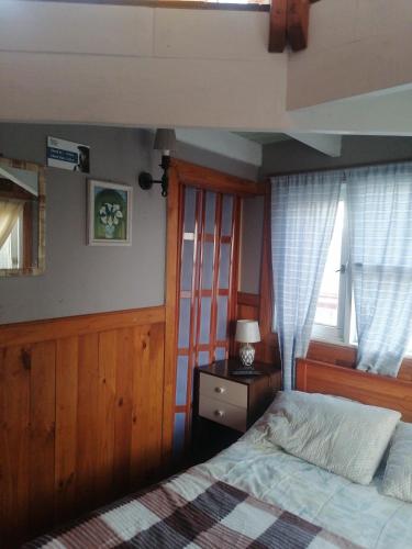 a bedroom with a bed and two windows at Habitación tu Refugio in Isla Negra