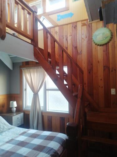 a bedroom with a staircase with a bed and a window at Habitación tu Refugio in Isla Negra