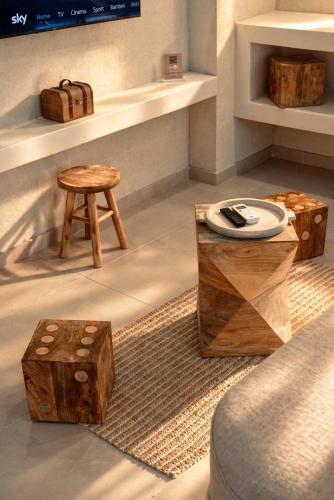 a living room with wooden stools and a table at Palermo Inn Boutique Hotel in Palermo