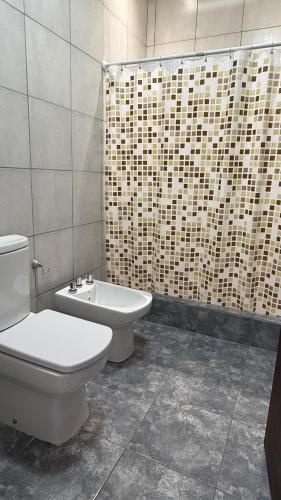 a bathroom with a toilet and a tub and a sink at Casa en planta alta in Rosario