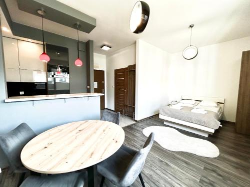 a room with a table and chairs and a bed at ApartmentPrestige Central Station in Krakow