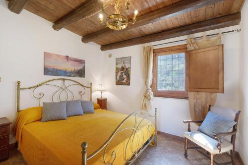 a bedroom with a yellow bed and a chair at Villa Gheta At The Monte Cofano in Custonaci
