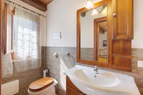a bathroom with a sink and a toilet and a mirror at Villa Gheta At The Monte Cofano in Custonaci