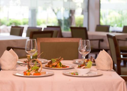 a table with plates of food and glasses of wine at Hotel Sudu Araliya in Polonnaruwa