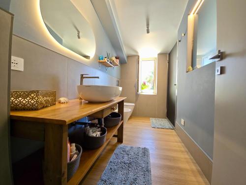 a bathroom with a bowl sink on a wooden counter at SuiteLina in Giardini Naxos