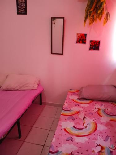 two beds in a room with pink walls at Boa Viagem Inn Pousada in Recife