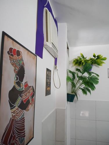 a bathroom with a painting of a woman on the wall at Boa Viagem Inn Pousada in Recife