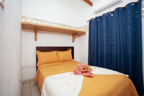 a bedroom with two beds and a blue curtain at Casa Osú in Sámara