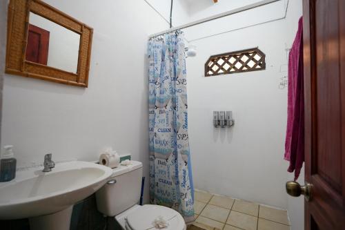 a bathroom with a toilet and a sink and a shower at Casa Osú in Sámara