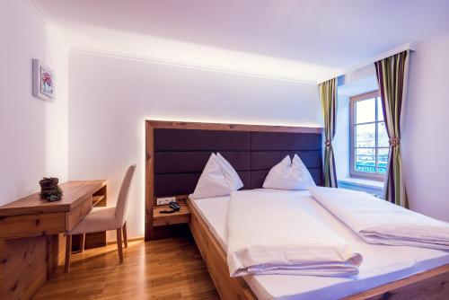 a bedroom with a bed and a desk and a bed sidx sidx sidx at Hotel Restaurant Stöcklwirt in Sankt Johann im Pongau