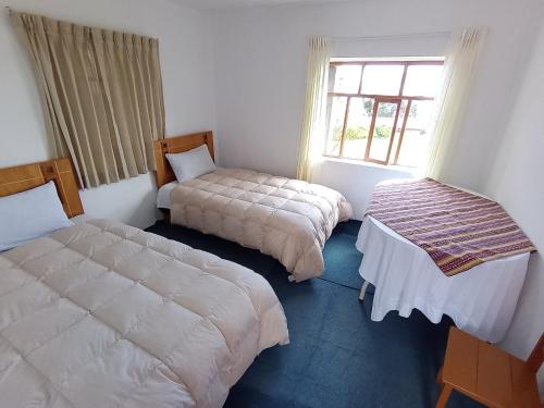 a room with two beds and a window at Casa Amadeus in Estanciasuyo